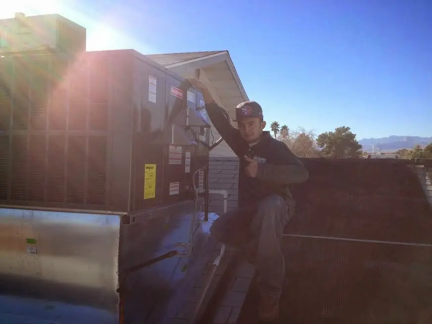 HVAC technician performing HVAC Inspection on a rooftop unit in Woodside