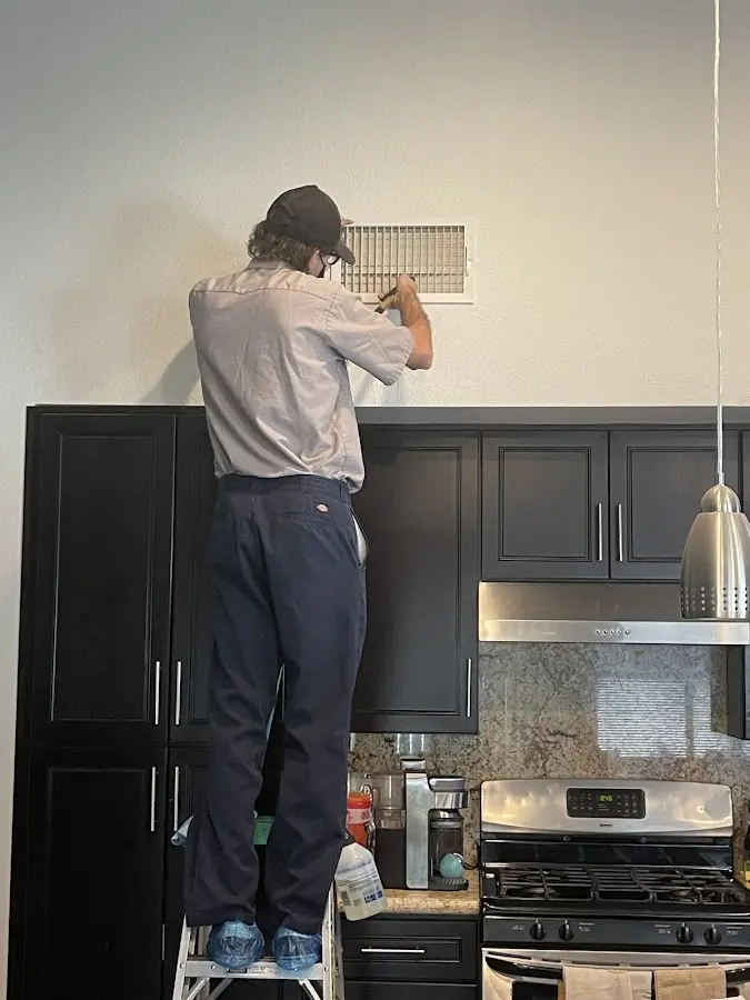 Technician inspecting an air vent during HVAC service in Woodside